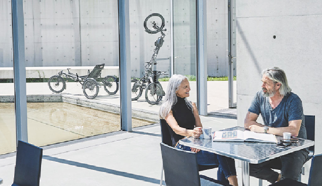 Beratungsgespräch vor einem Hase Bikes EVOS STEPS Dreirad